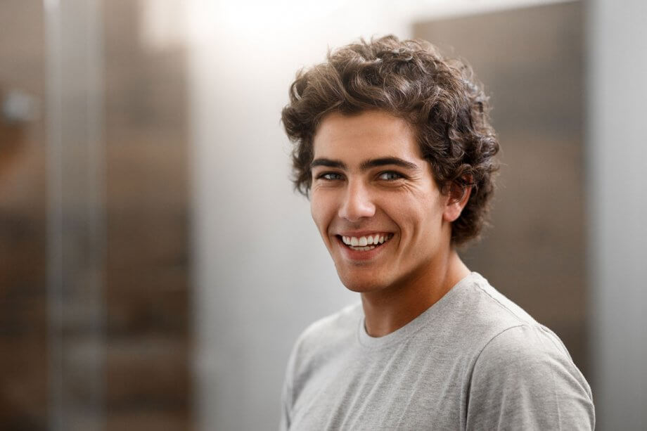 teen boy wearing grey t-shirt, smiling
