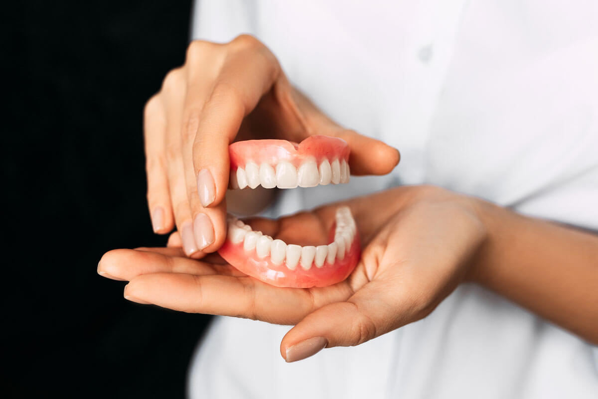 person holding dentures